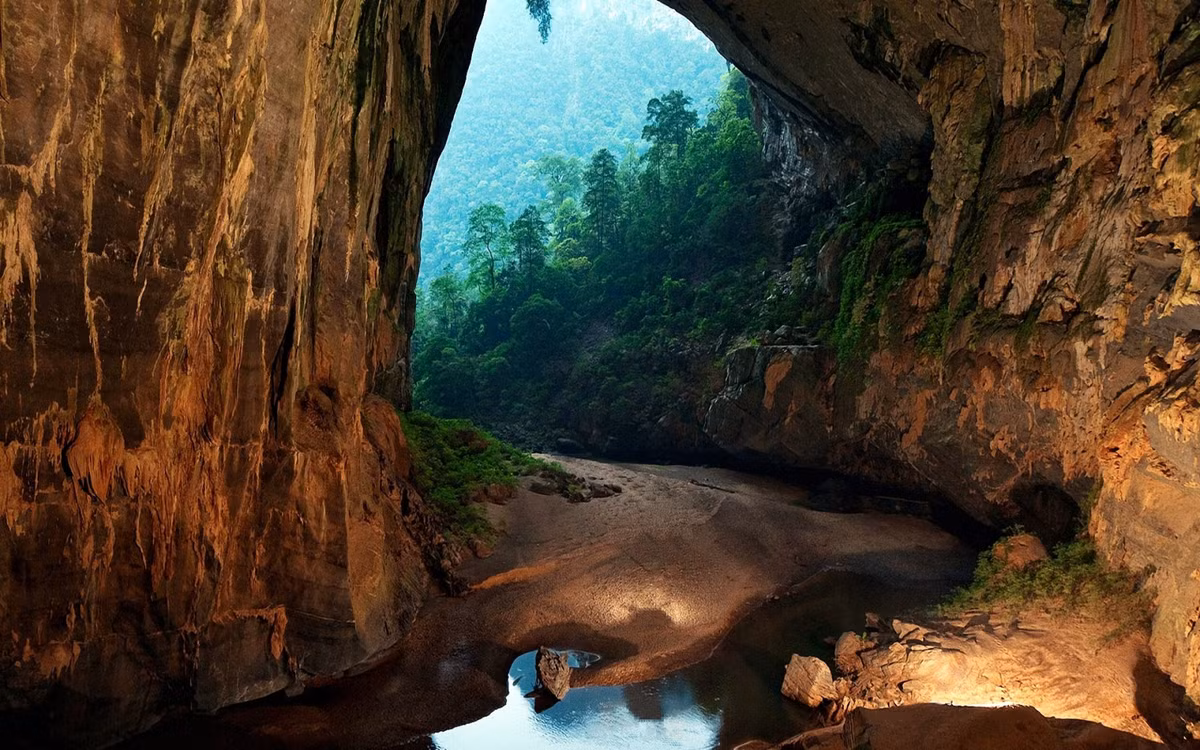 Hang Sơn Đoòng thuộc quần thể hang động Phong Nha - Kẻ Bàng, toạ lạc tại xã Sơn Trạch, huyện Bố Trạch, tỉnh Quảng Bình nước ta. Theo các nhà địa chất học, hang Sơn Đoòng được hình thành cách đây khoảng 2 - 5 triệu năm với chiều dài ước tính ít nhất là 6,5 km, cao 200 m, rộng 150 m. Với kích thước như trên, hang Sơn Đoòng vượt lên kỷ lục thế giới của hang Deer trong vườn quốc gia Gunnung Mulu (Malaysia), trở thành hang động tự nhiên lớn nhất, hoành tráng và lộng lẫy nhất thế giới. Ảnh: Hang Sơn Đoòng tự như chốn bồng lai tiên cảnh giữa núi rừng. (Nguồn: Wordpress.com).