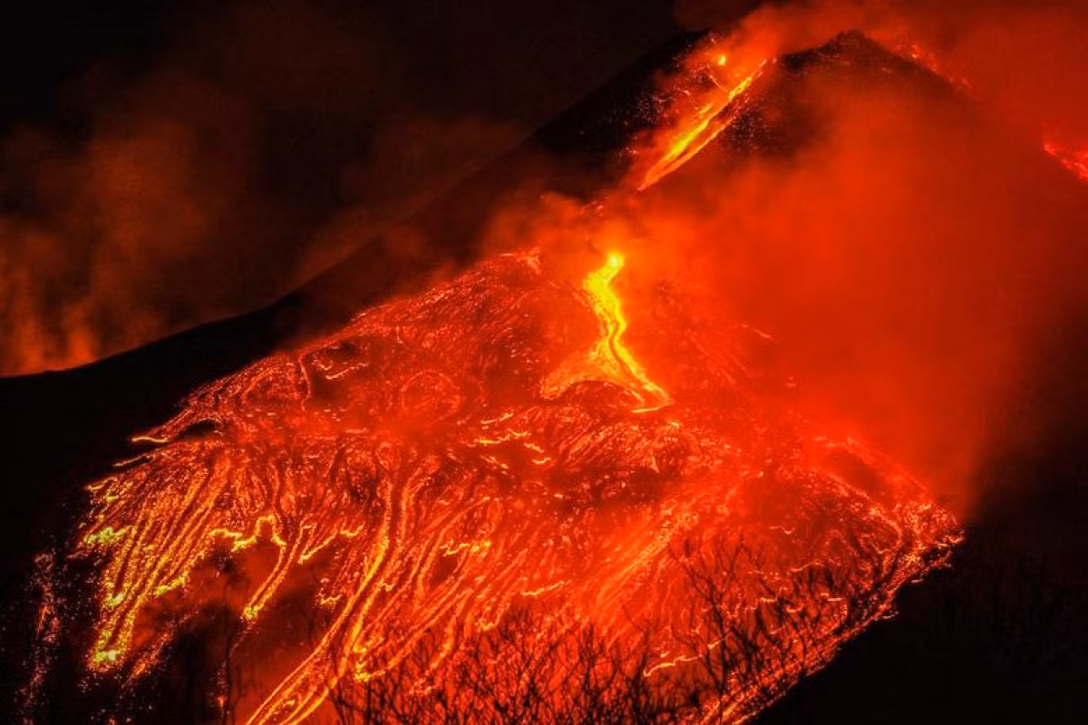 Dòng dung nham đỏ rực phun trào từ núi lửa Etna, núi lửa hỏa động mạnh nhất ở châu Âu, nhìn từ làng Formazzo, Italy, ngày 23/2/2021.