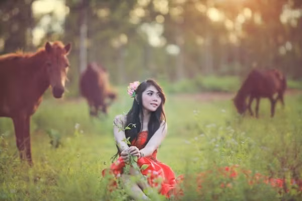 Cô gái nổi bật trên cánh đồng, bên bầy ngựa.