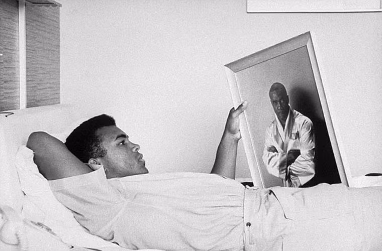 Muhammad Ali chăm chú nhìn tấm ảnh chụp võ sĩ quyền Anh Sonny Liston, người lúc đó ông đang huấn luyện để đi thi đấu.