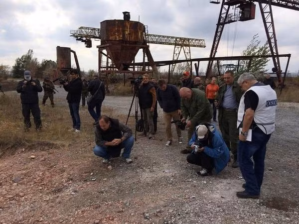 Các nhà điều tra làm việc ở hiện trường một hố chôn tập thể ở gần Donetsk.