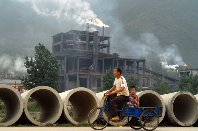 Những cột khói cao nghi ngút tỏa ra môi trường xung quang tại một nhà máy xi măng ở Baokang, TQ.