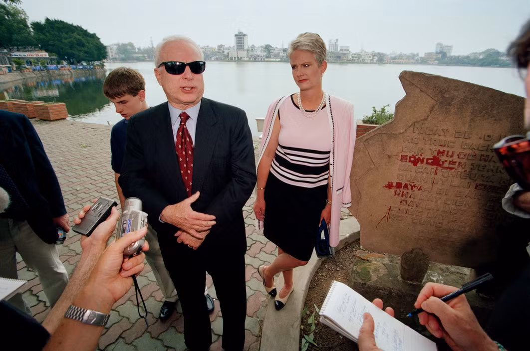 Ông John McCain cùng vợ và con trai tiếp xúc với báo chí bên đài kỷ niệm ở hồ Trúc Bạch. Ảnh: Philip Jones Griffiths/ Magnum.