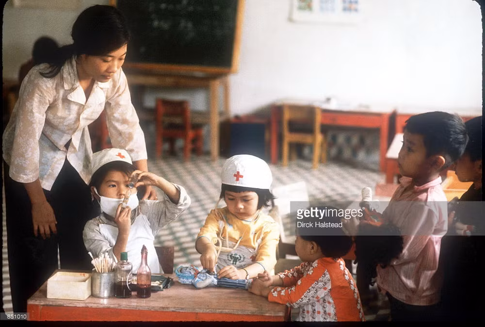 Cô giáo quan sát các em nhỏ chơi trò làm bác sĩ trong một trường mầm non ở Vinh.
