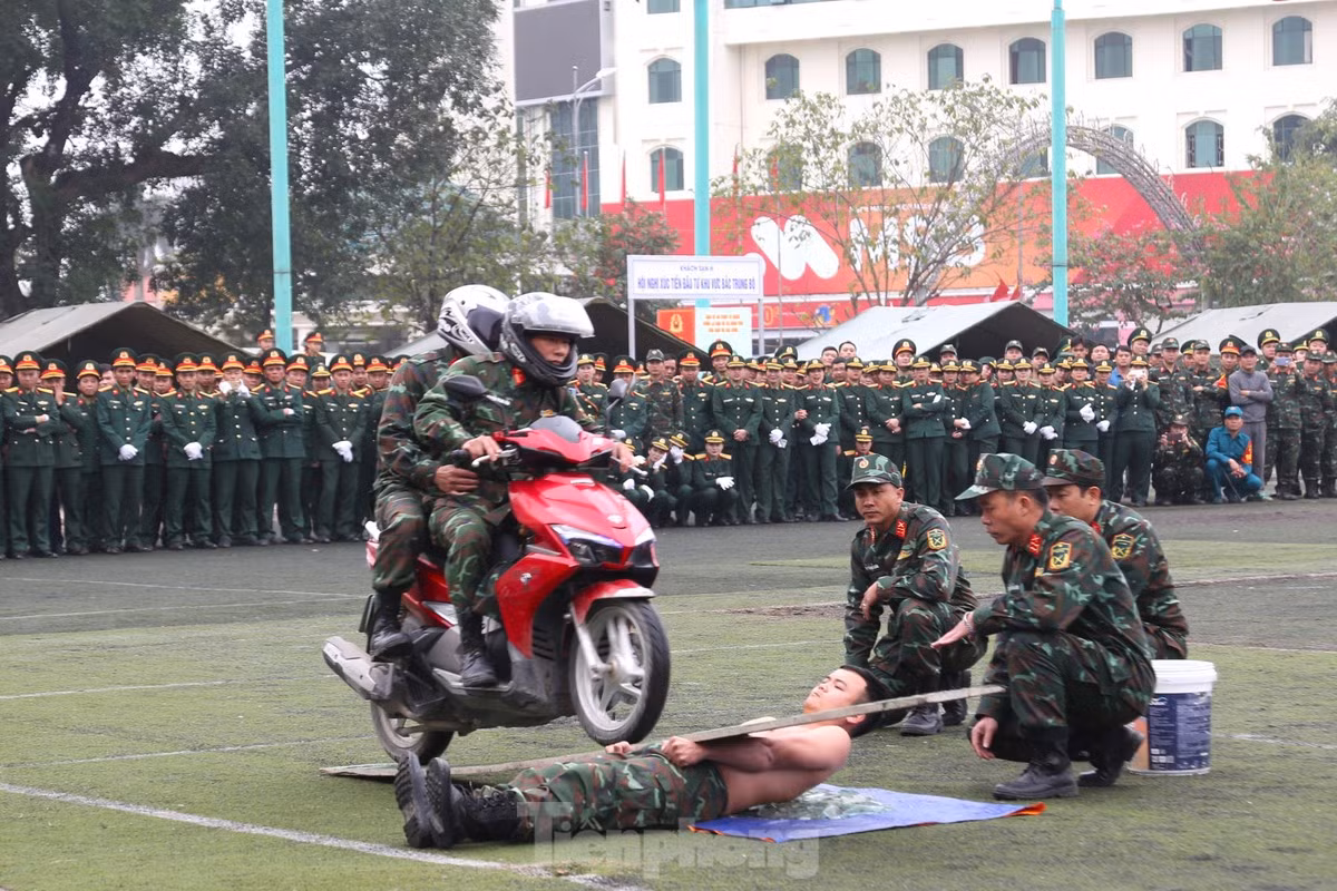 Cho xe máy chạy trên tấm ván qua người trần nằm trên mảnh thủy tinh vỡ.