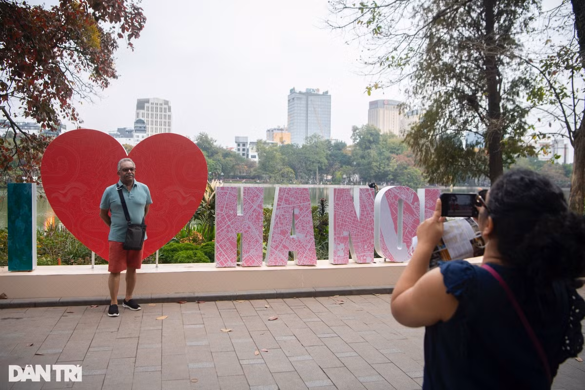 Nhiều du khách nước ngoài tranh thủ ghi lại những kỷ niệm đẹp tại hồ Hoàn Kiếm trong ngày cuối cùng của năm 2023.