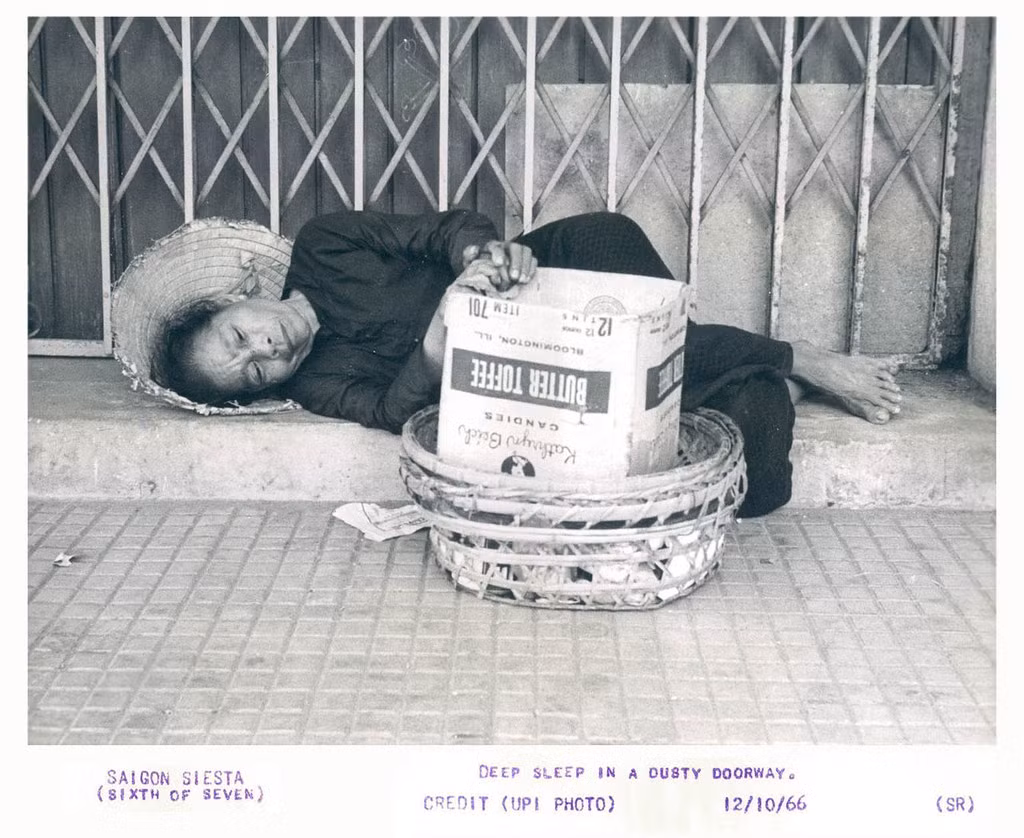 Người bán hàng rong ngủ trên vỉa hè, tay vẫn đặt trên giỏ hàng, Sài Gòn năm 1966.