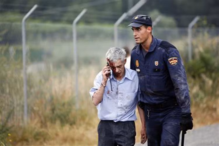Thủ tướng Tây Ban Nha Mariano Rajoy đang trên đường tới hiện trường vụ tai nạn. Trong ảnh, nhân viên cứu hộ đỡ một nạn nhân mặt đầy máu ra khỏi hiện trường.