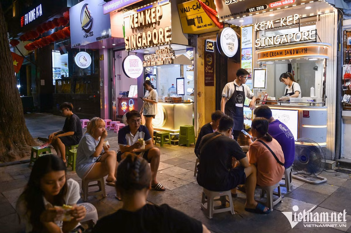 Hai hàng kem kẹp cạnh nhau "tận dụng" vỉa hè phố đi bộ bên hồ Hoàn Kiếm để phục vụ khách. Ước tính vào mỗi tối dịp cuối tuần, các tiệm này bán hàng trăm chiếc.