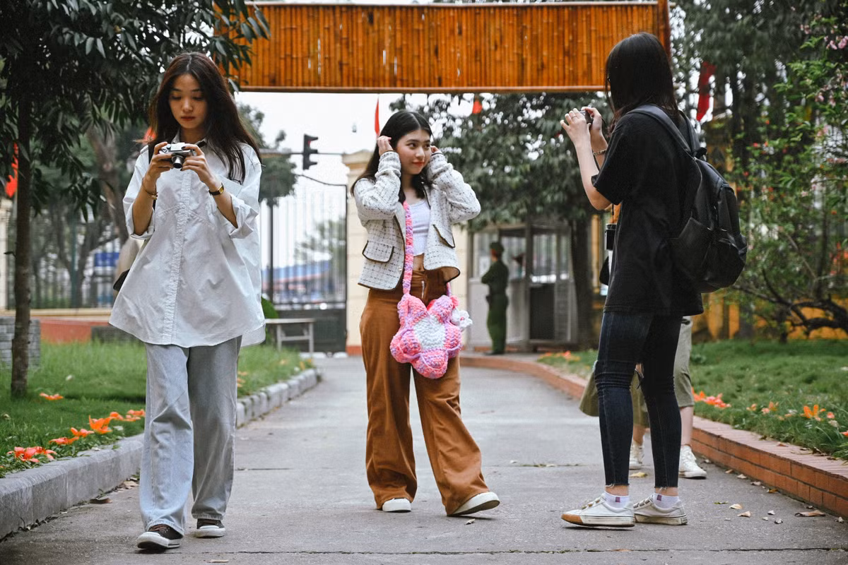 Những bông hoa gạo rụng dưới thảm cỏ cũng tạo nên ý nghĩa riêng, thu hút nhiều bạn trẻ.