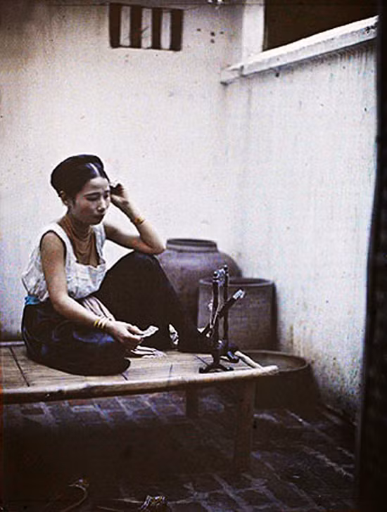 Một phụ nữ Hà Nội nhà giàu ngồi trang điểm trên chõng tre.