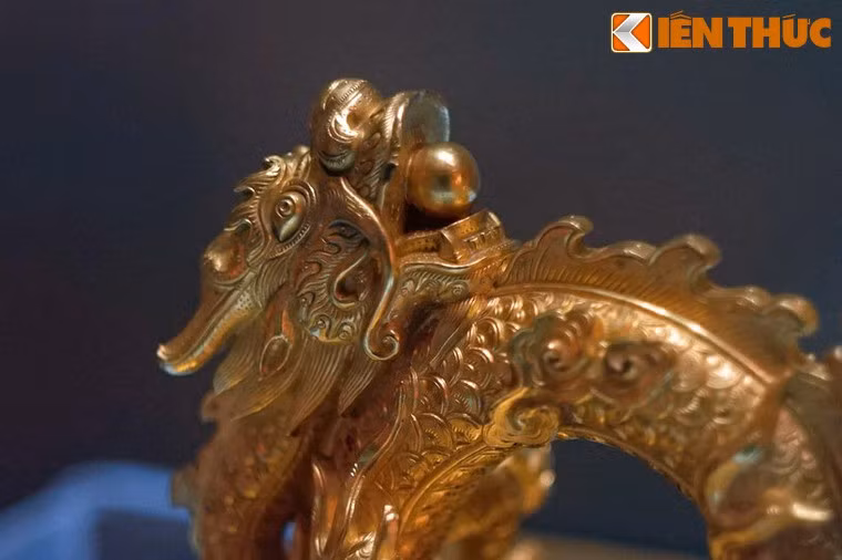 Cận cảnh đầu rồng với hòn ngọc trong miệng ở núm cầm ấn Quốc gia tín bảo. Triều Nguyễn (1802-1945) là triều đại phong kiến cuối cùng của Việt Nam, trải qua 143 năm tồn tại đã để lại khối di sản văn hóa đồ sộ chứa đựng những tinh hoa văn hóa nghệ thuật của dân tộc.