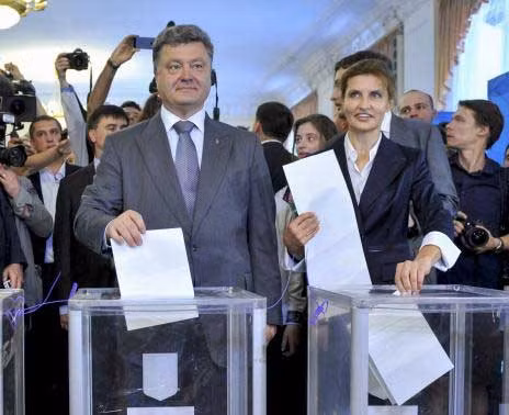 Doanh nhân, chính trị gia và là ứng viên tổng thống Petro Poroshenko (bên trái) cùng vợ Maryna tới một địa điểm bỏ phiếu ở Kiev hôm 25/5.