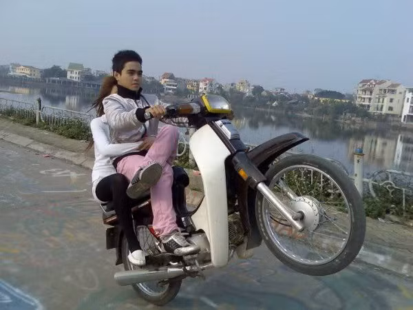 Vắt chéo chân, không đội mũ bảo hiểm vẫn vô tư ngồi trên xe máy và "biểu diễn"