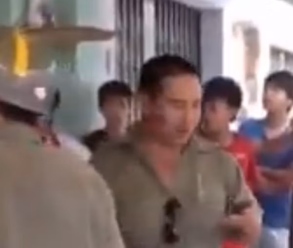 Một dân phòng bụng phệ sử dụng điện thoại gọi công an phường đến.