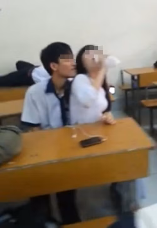 Đôi nam, nữ sinh có những hành động tình tứ trong lớp gây "nhức mắt". Ảnh cắt từ clip.