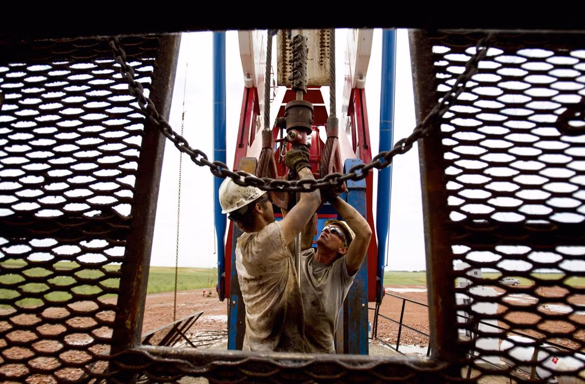 Anh Austin Mitchell (trái) và Ryan Lehto, làm việc trên một cần cẩu dầu bên ngoài Williston, tiểu bang North Dakota. Công việc của họ khá cực nhọc và quần áo cũng thường xuyên bị lấm bẩn.