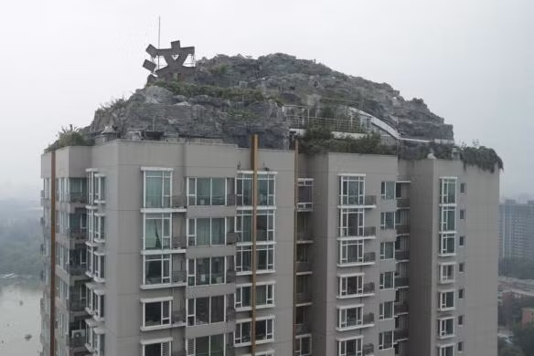 Biệt thự được bao quanh bằng một quần thể đá giả và cây xanh nằm trên nóc của một tòa chung cư thuộc khu đô thị Renji Shanzhuang, Thủ đô Bắc Kinh, Trung Quốc.