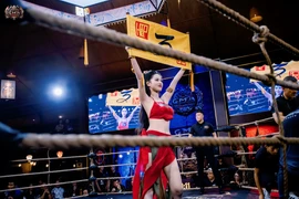 Nữ cosplayer Nguyễn Hữu Kiều Oanh diện áo yếm cầm biển tại sàn MMA
