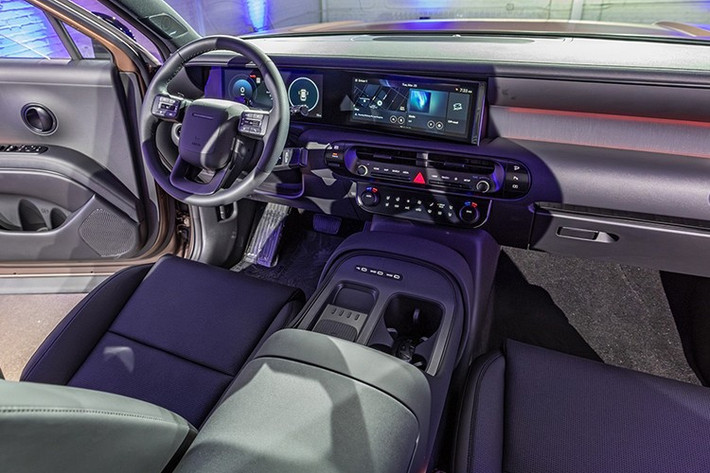 Khoang lái của Palisade Hybrid mang đậm phong cách Genesis, pha trộn hiện đại và sang trọng. Các chi tiết như cửa gió điều hòa hình oval, tay nắm cửa tròn và màn hình cong 12,3 inch tích hợp liền khối với bảng điều khiển trung tâm đều gợi nhớ đến các mẫu SUV cao cấp.