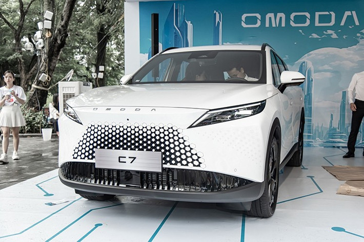Được áp dụng ngôn ngữ thiết kế "Art in Motion", Omoda C7 sở hữu ngoại hình khá ấn tượng với nắp ca-pô nhô về phía trước như mỏ chim, cụm đèn pha sắc sảo và lưới tản nhiệt không viền, hòa lẫn vào cản trước. Bên trong lưới tản nhiệt là những chi tiết hình lục giác, sơn cùng màu thân xe, gợi liên tưởng đến Lexus RX thế hệ mới.