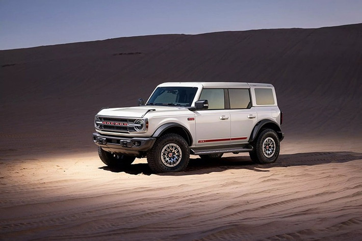 Điểm nhấn của mặt trước Ford Bronco 2026 bản kỷ niệm là ngoại thất sơn màu trắng, dòng chữ “BRONCO” sơn màu đỏ - Vermilion Red hiện đại. Lưới tản nhiệt mới lấy cảm hứng từ thiết kế gốc nhưng kết hợp sơn Warm Alloy. Đây là tông màu lịch sử của Ford có trên Bronco.