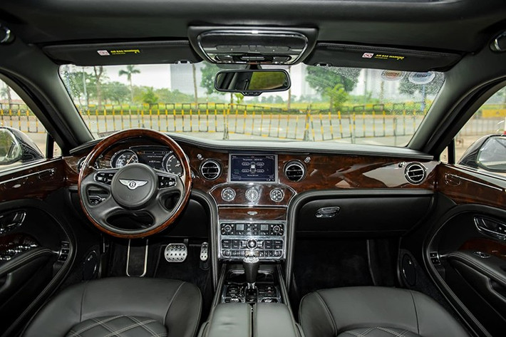 Mở cửa bước vào bên trong khoang lái, Bentley Mulsanne Le Mans Edition có dòng chữ Le Mans Edition được thắp sáng trên bậc cửa, ghế ngồi có các đường chỉ câu tương phản trên các khu vực chần kim cương...