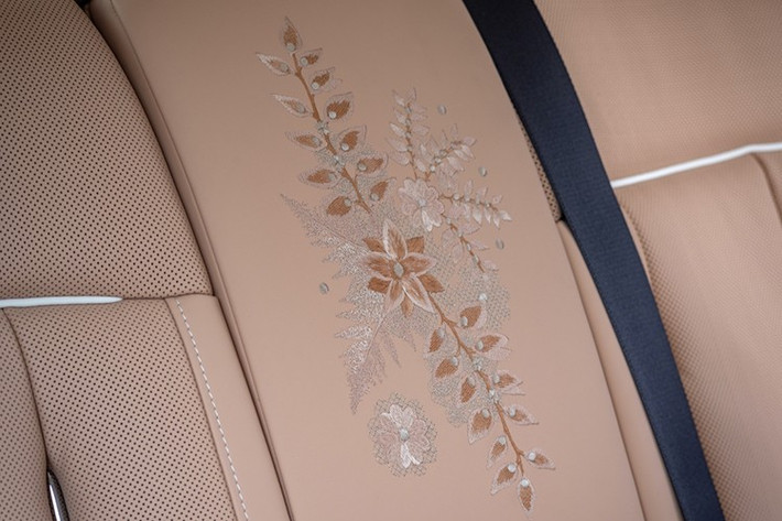 Trên phiên bản độc nhất này, các nhà thiết kế Bespoke đã sáng tạo nên một bức tranh hoa từ vải ren cao cấp, sử dụng đa dạng kỹ thuật thêu, mật độ chỉ và sắc độ màu – Rose Gold, Sunrise và Oatmeal – nhằm tái hiện sống động kết cấu của từng cánh hoa và lá dương xỉ.