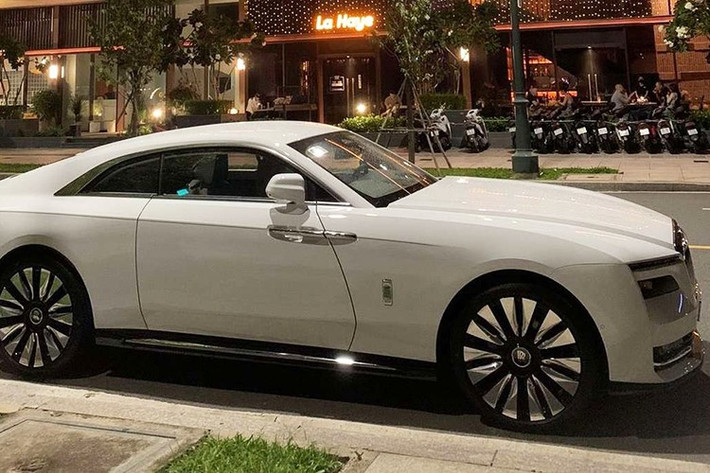 Chiếc xe siêu sang Rolls-Royce Spectre của đại gia Minh Nhựa có màu sơn trắng, điểm nhấn của xe nằm ở việc trên lưới tản nhiệt huyền thoại của một mẫu xe Rolls-Royce, chiếc coupe siêu sang chạy bằng điện Spectre này lại sở hữu logo Spirit of Ecstasy không phải bằng bạc hay mạ vàng quen thuộc mà là bằng chất liệu polycarbonate, hay nói dễ hiểu hơn là phát sáng vào ban đêm.