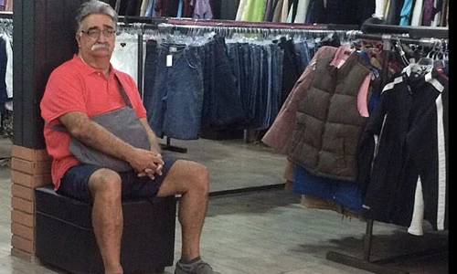 Cảnh nam giới vạ vật ngồi chờ trong các hiệu thời trang