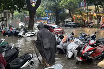 Xe để trên vỉa hè phố Trần Hưng Đạo cũng bị ngập quá nửa bánh. Ảnh: Thanh Thúy.