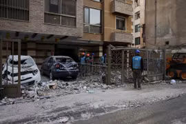 Lực lượng cứu hộ kiểm tra hiện trường một tòa nhà bị hư hại sau vụ không kích tại khu dân cư ở Lebanon, nhiều phương tiện bị phá hủy và mảnh vỡ vương vãi trên đường phố, cho thấy mức độ tàn phá của các đợt giao tranh leo thang.