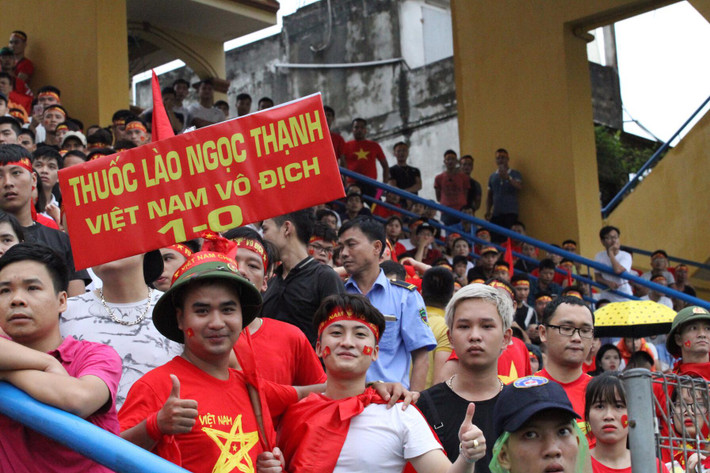 Các cổ động viên mặc áo cờ đỏ sao vàng, mang theo quốc kì và hừng hực khí thế cổ vũ cho đội nhà.