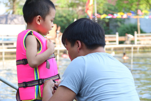 Nhiều gia đình đưa con nhỏ ra ao tắm vào các buổi chiều, các em đều được mặc áo phao bảo hộ.