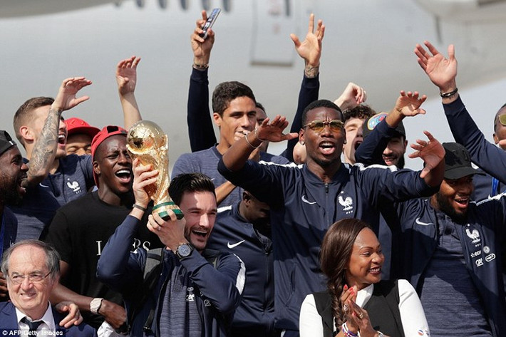 Paul Pogba và các đồng đội ăn mừng trước các phóng viên có mặt ở sân bay Charles de Gaulle.