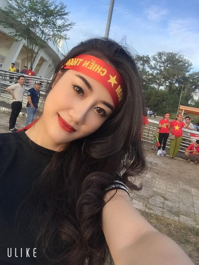 Cô gái mặc một bộ váy liền thân, tay cầm chiếc băng buộc đầu với khẩu hiệu: "Việt Nam vô địch". Sở hữu gương mặt xinh đẹp, nước da trắng mịn, điều đáng chú ý nhất chính là vóc dáng cực chuẩn của cô nàng.