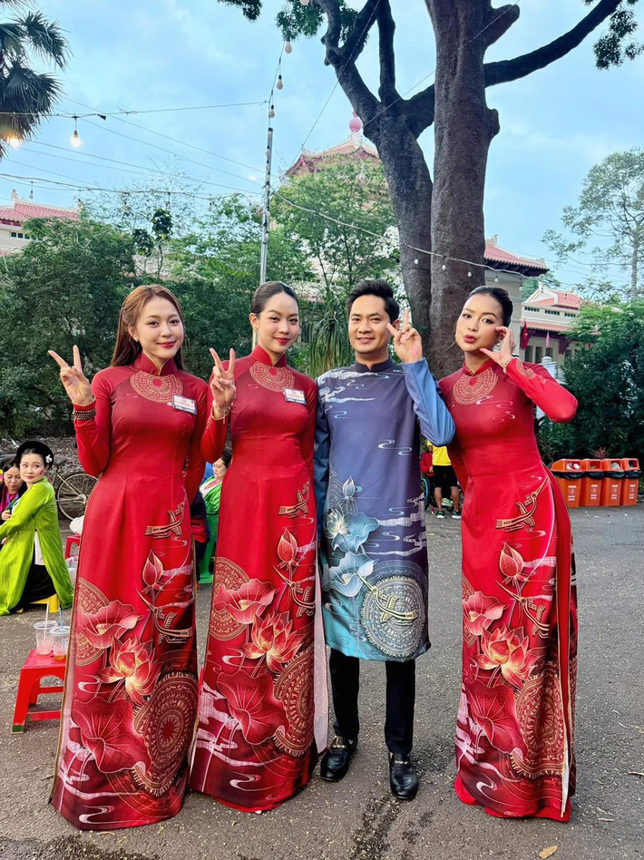 Hoa hậu Thanh Thủy, Ngọc Châu diện áo dài đỏ, tranh thủ check-in trước giờ diễu binh, diễu hành.