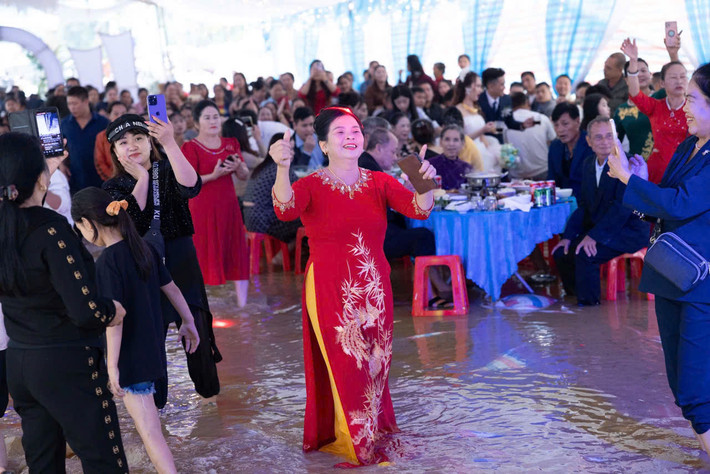 Theo đó, cả rạp cưới đều ngập nước vì mưa lũ. Hình ảnh cô dâu chú rể cùng hàng trăm quan khách bì bõm lội nước khiến nhiều người phải bật cười.