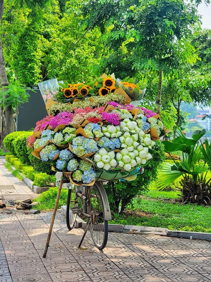 Những chiếc xe đạp nhỏ bé nhưng lại mang trên mình những bó hoa to, rực rỡ cả một góc trời... (Ảnh: Đinh Xuân Tiến)