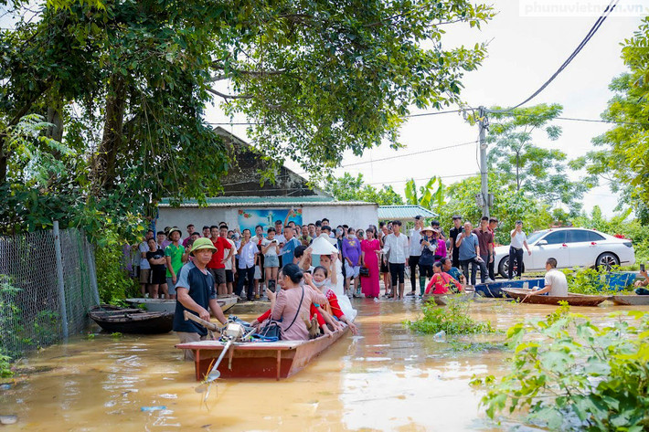 Trên MXH những đám cưới đón dâu bằng thuyền phao tự chế không hiếm nhưng mỗi lần xuất hiện nó lại khiến nhiều người chú ý. Mới đây nhất, đám cưới của cặp đôi gen Z là Nguyễn Thị Huyền và Nguyễn Văn Luyện tại huyện Chương Mỹ - Hà Nội nơi đang bị ngập lụt nghiêm trọng là một điểm hình. Ảnh: Phụ nữ Việt Nam