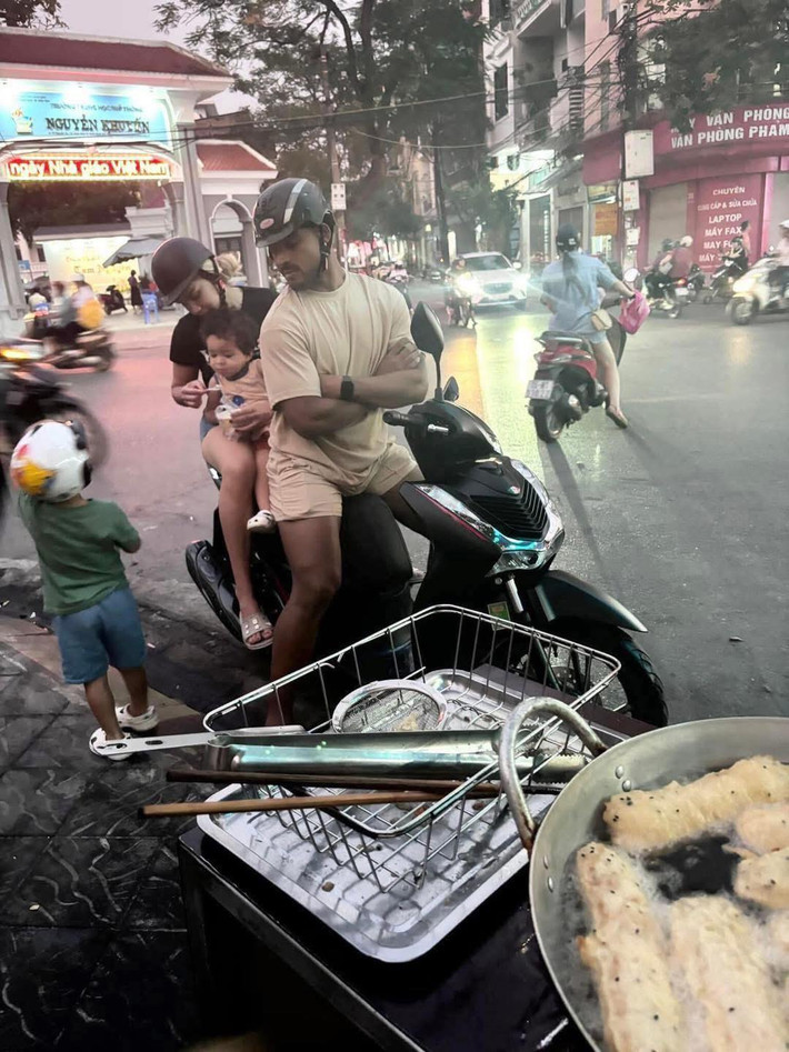 Trong bức ảnh, Xuân Son và bà xã Marcele Seippel xuất hiện với hình ảnh vô cùng đời thường. Hai người cùng nhau đi xe máy, mặc những bộ quần áo giản dị, đứng chờ mua bánh chuối như bao người khác.