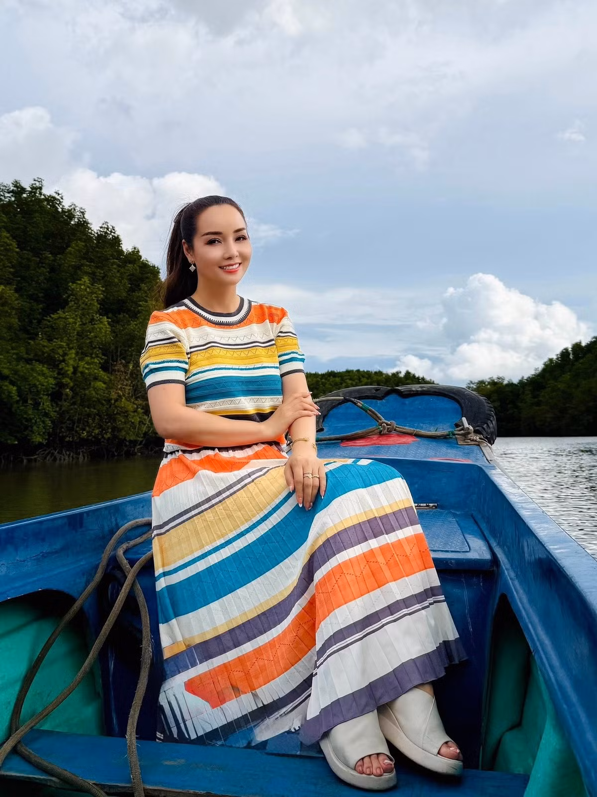 Mai Thu Huyền diện váy màu sắc rực rỡ ở sông Mê Kông. Ảnh: FB Mai Thu Huyen