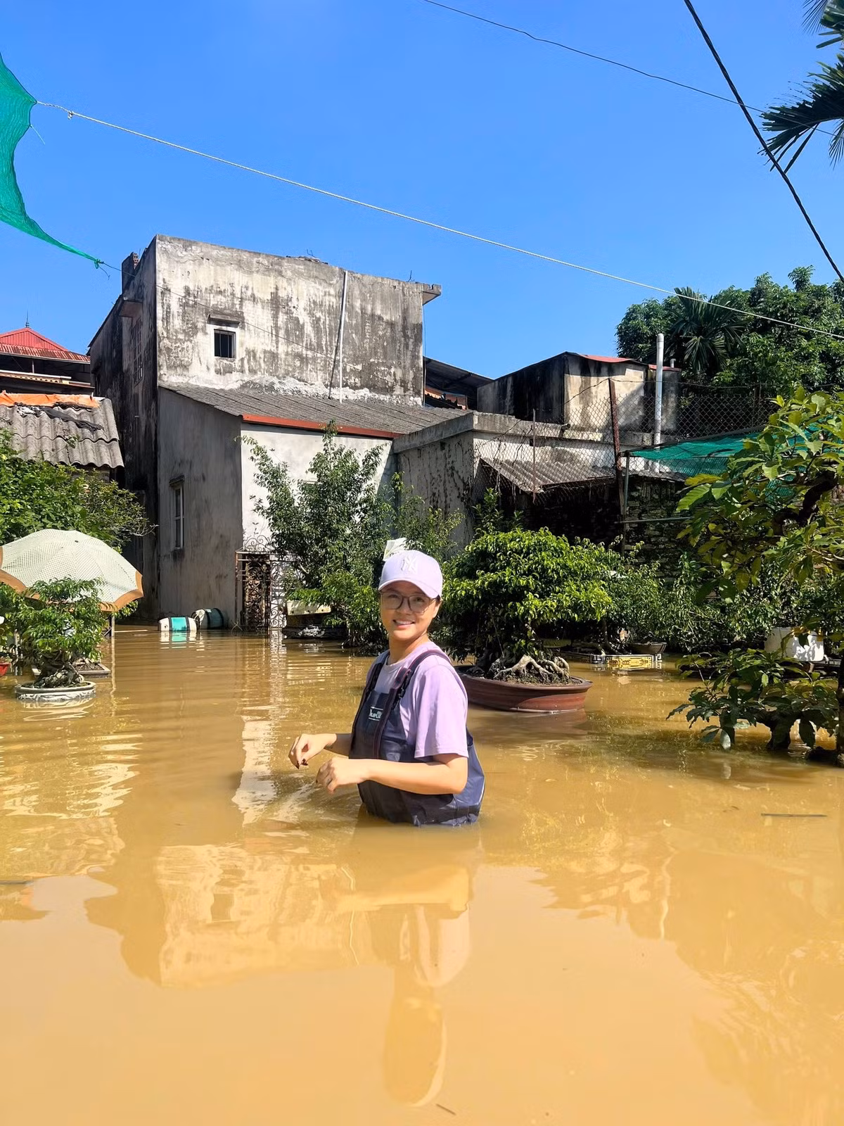 Diễn viên Thu Quỳnh check in giữa vùng nước ngập tới ngang hông. Ảnh: FB Nguyễn Thu Quỳnh