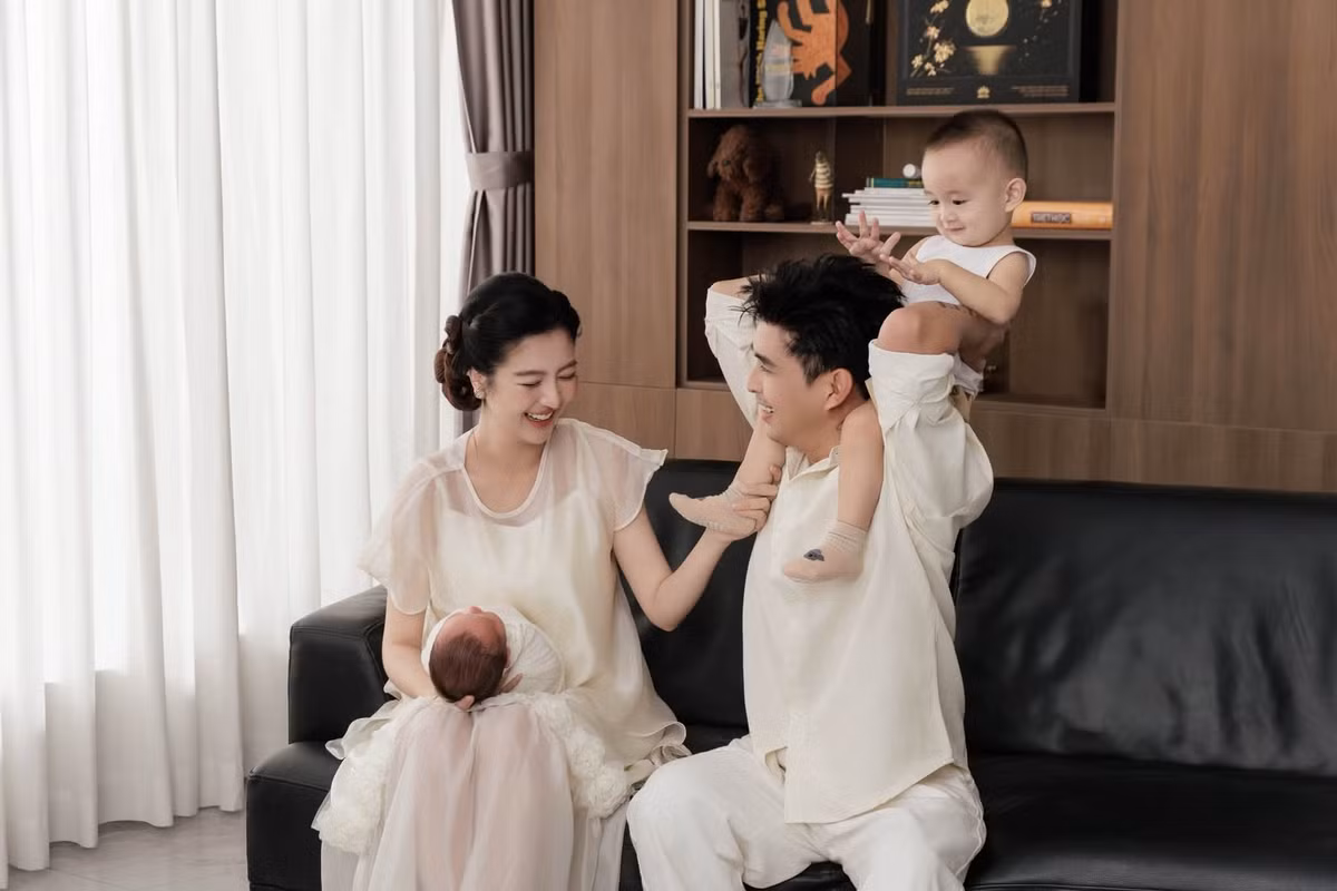 Trong bộ ảnh, các thành viên lựa chọn trang phục tông trắng nhẹ nhàng, tạo cảm giác thanh lịch và gần gũi. Những khoảnh khắc cả nhà quây quần bên nhau, cùng hướng ánh nhìn về hai con mang đến không khí ấm áp. Hình ảnh gia đình bốn thành viên cũng cho thấy niềm hạnh phúc của vợ chồng Hồ Quang Hiếu khi tổ ấm có thêm thành viên mới. Ảnh: FB Hồ Quang Hiếu
