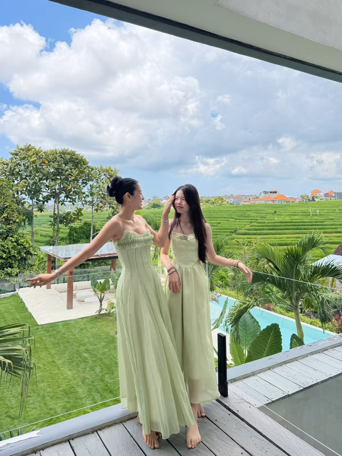 Trong ảnh, nữ diễn viên và con gái diện váy đôi màu xanh lá, tạo dáng thân thiết giữa khung cảnh biển trời trong lành.