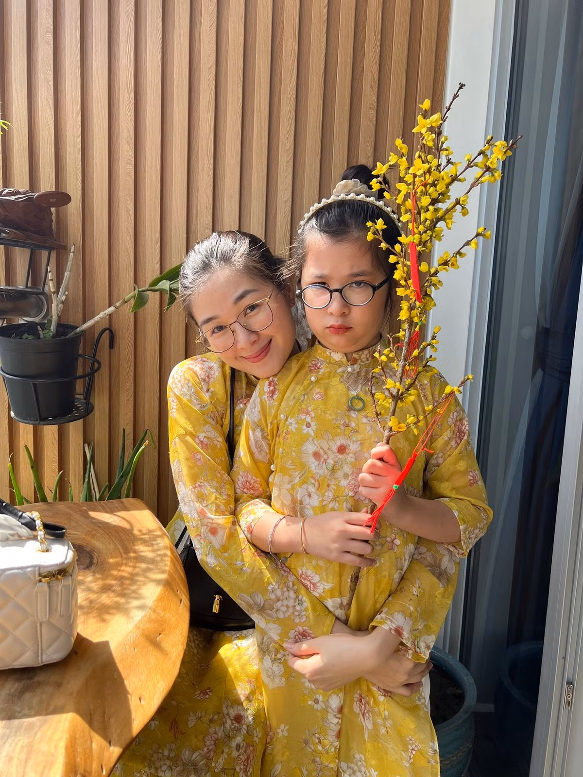 Mạc Anh Thư và bé Cát diện áo dài, sắm cành mai chuẩn bị đón Tết. Ảnh: FB Mạc Anh Thư