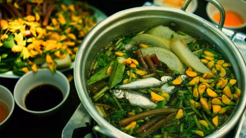 Đặc biệt, nếu ghé An Giang vào mùa nước nổi, du khách không nên bỏ qua canh chua cá linh. Cá linh được nấu cùng bông điên điển, bông súng hoặc rau muống, tạo nên món canh mang đậm hương vị mùa nước nổi miền Tây. Vị chua thanh của me hòa quyện với vị ngọt của cá và độ giòn tươi của rau, mang đến cảm giác dân dã mà cuốn hút. Ảnh: Bách hoá XANH