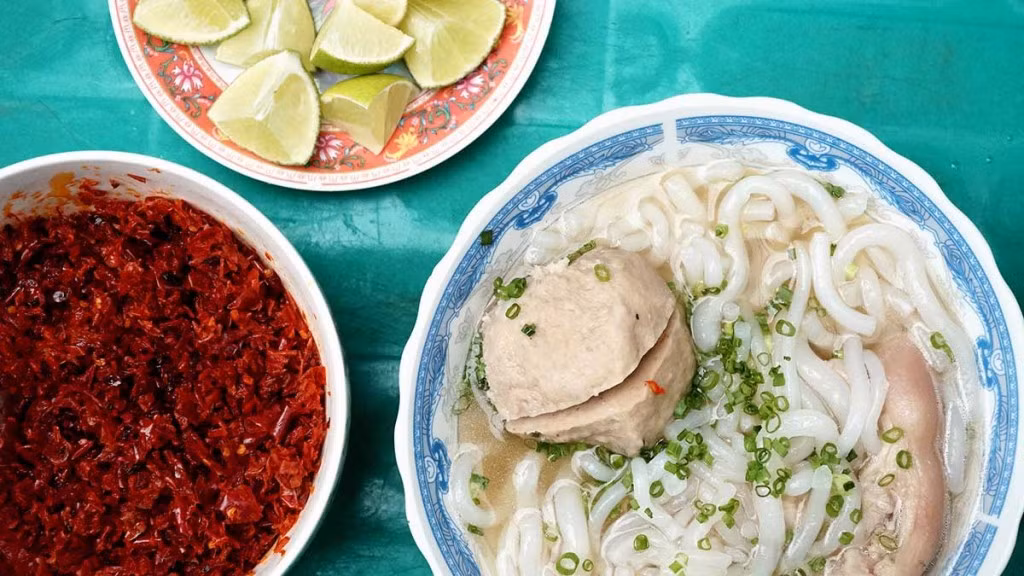 Nếu yêu thích những món ăn nóng hổi, du khách có thể thưởng thức bánh canh bò viên Bảy Núi. Món ăn nổi bật với những viên bò to tròn, dai giòn tự nhiên, hòa quyện cùng nước dùng ngọt đậm được hầm từ xương bò. Sợi bánh canh mềm dai, ăn kèm chân giò, rau sống và chút tương ớt cay nồng, mang đến hương vị đậm đà khó quên. Ảnh: ivivu