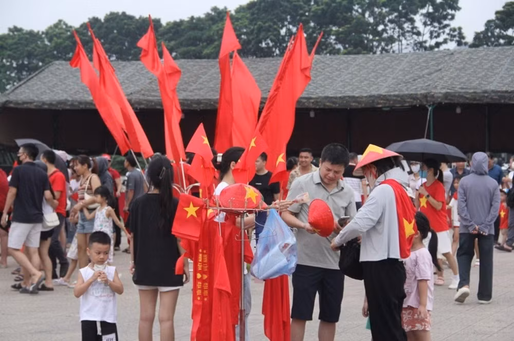 Người dân và du khách mua các phụ kiện để chụp ảnh, góp phần "nhuộm đỏ" không gian khu vực sân Mỹ Đình.