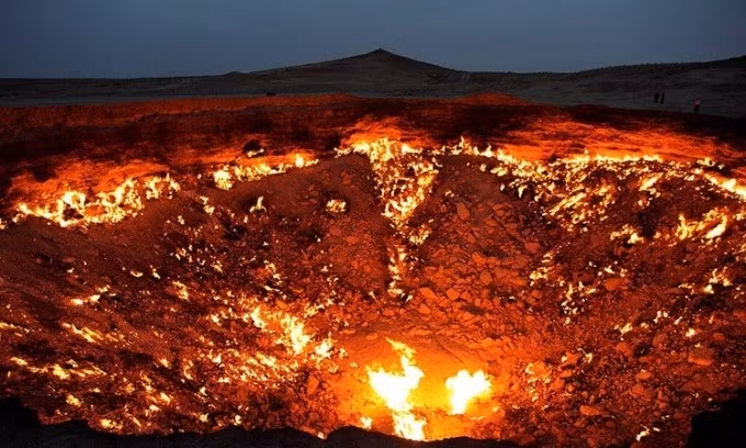 "Cổng địa ngục" ở Turkmenistan là một hố sụt rộng 70m tại sa mạc Karaku. Vào những năm 1970, một trạm khoan khí của Liên Xô tình cờ khoan thủng túi khí và sụp xuống đất, tạo thành miệng hố bắt đầu rò rỉ khí. Ảnh: Wikimedia.
